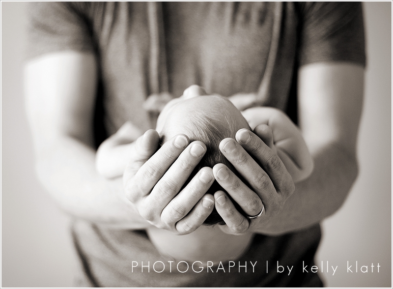 Portrait of father holding newborn by Kelly Klatt Photography