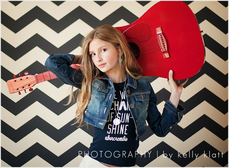 Girl posing with red guitar by Kelly Klatt Photography