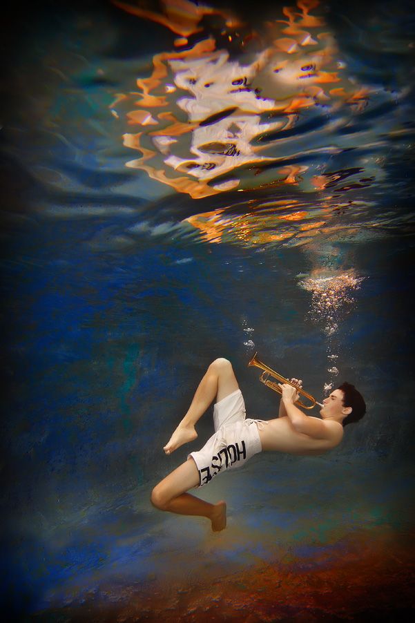 Portrait of boy playing instrument underwater by Kirk Voclain Photography