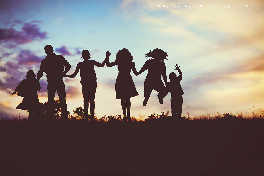 Silhouette of children jumping in front of sunset by My Four Hens Photography