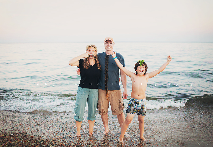 Portrait of family in front of ocean by My Four Hens Photography