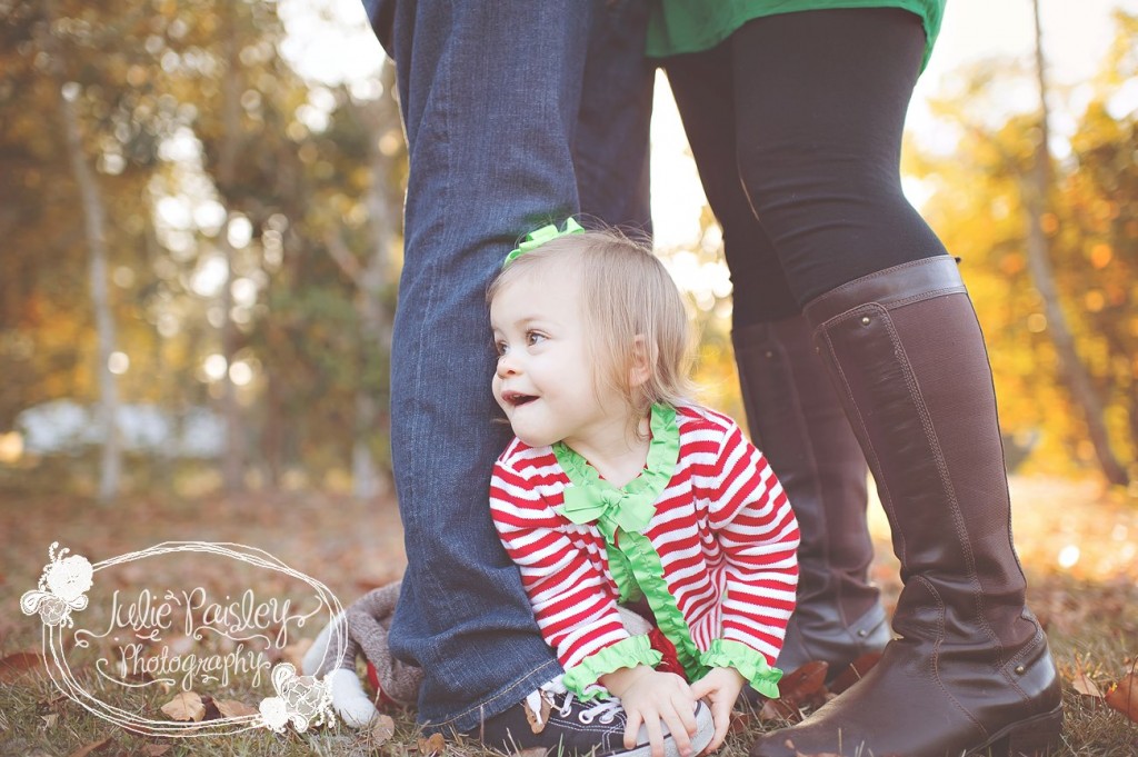 Little girl sitting at parents' feet by Julie Paisley photography
