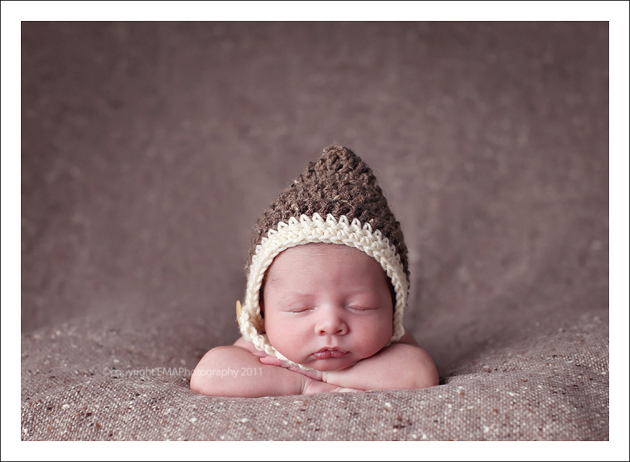 Portrait of baby in crocheted hat by EMA PHOTOGRAPHY