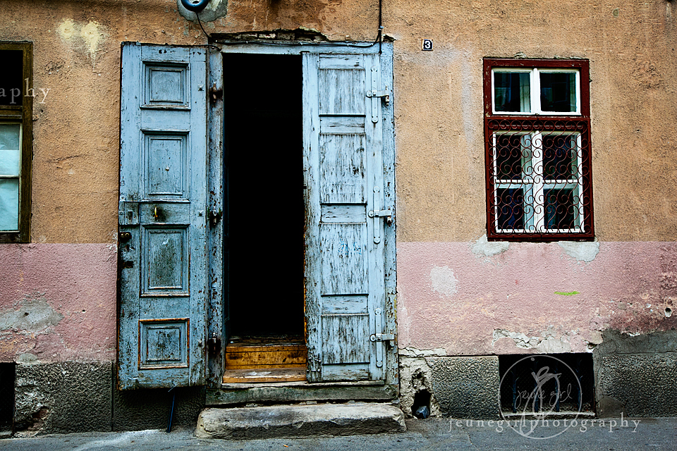 Portrait of building with rustic doors by Jeune Girl