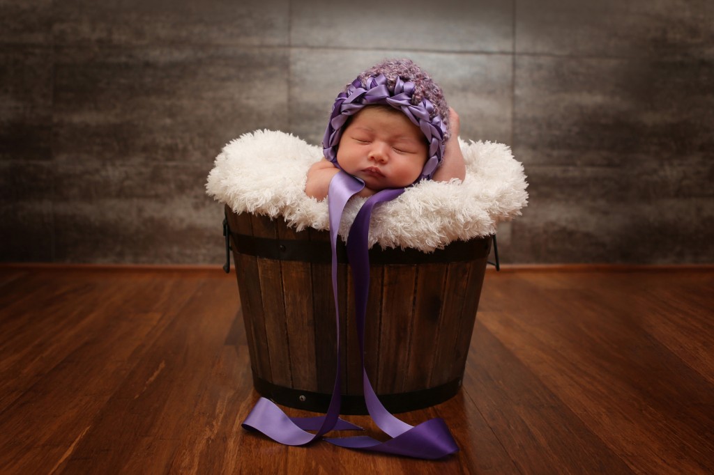 Portrait of newborn laying in basket by Anja McDonald Photography