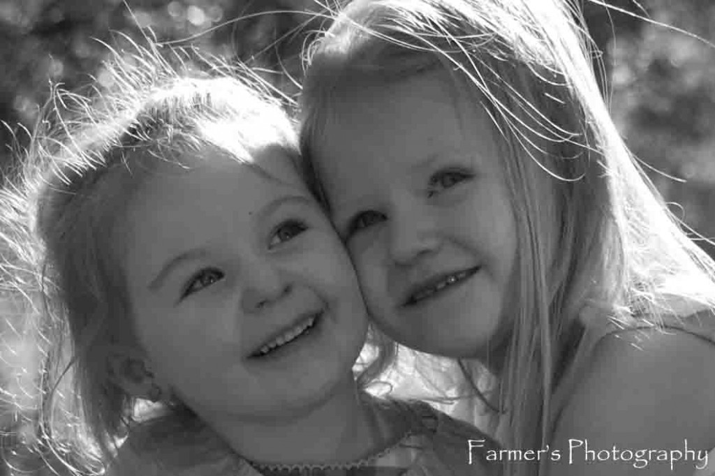 Portrait of two sisters hugging outside by Farmer's Photography