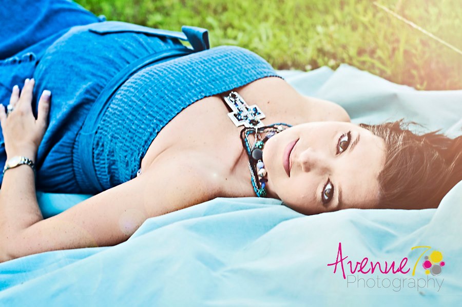 Portrait of girl laying in grass by Avenue 7 Photography