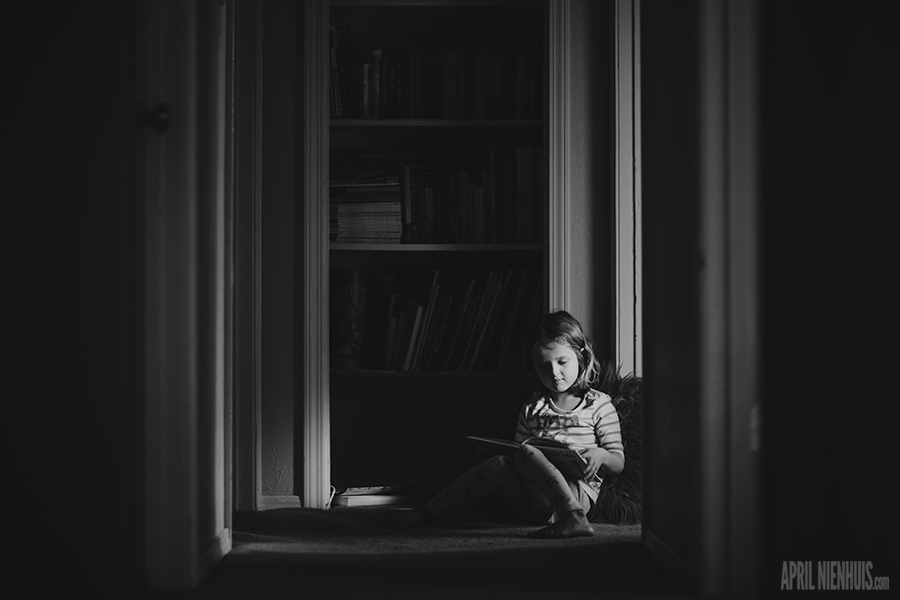 young girl reading a book in a hallway picture by April Nienhuis
