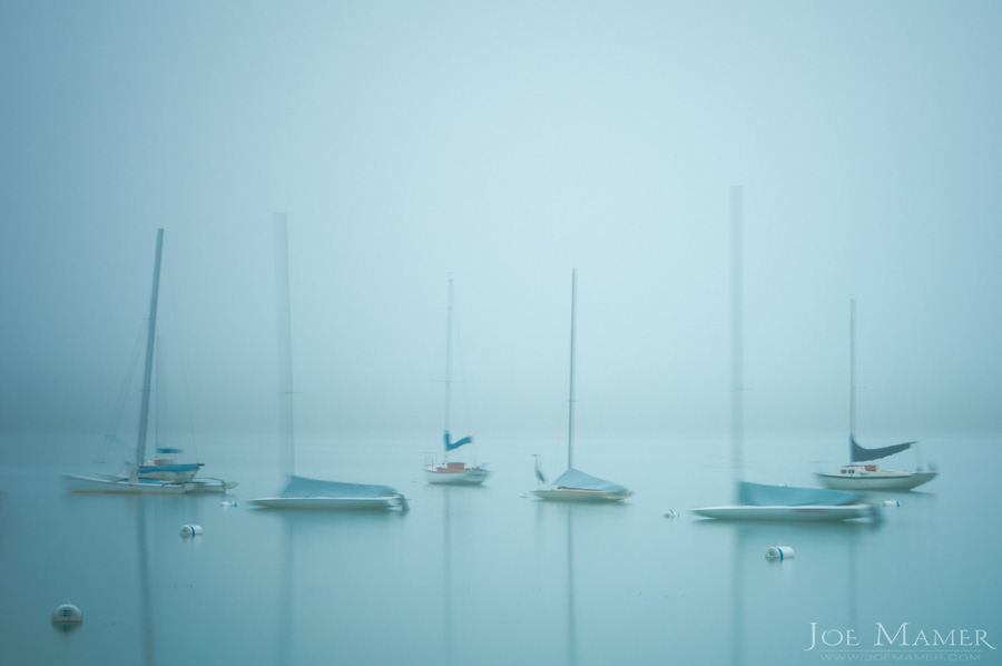 Sailboats on fog shrouded Lake Harriet at dawn.