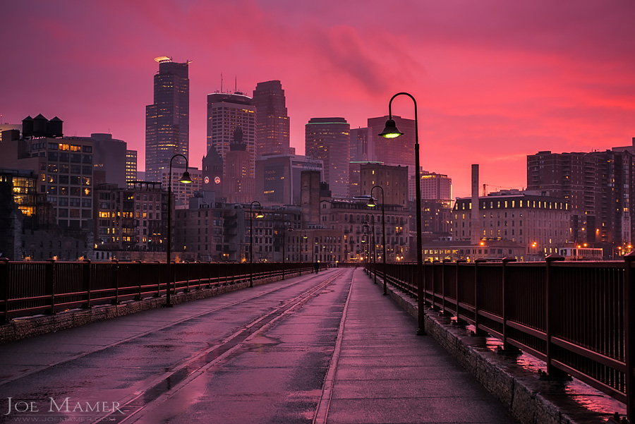 Minneapolis skyline from the Stone Arch Bridge as a rain storm breaks at sunset.